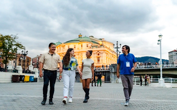 Group walking near Bilbao's Arriaga Theater during Guggenheim and Gaztelugatxe tour.