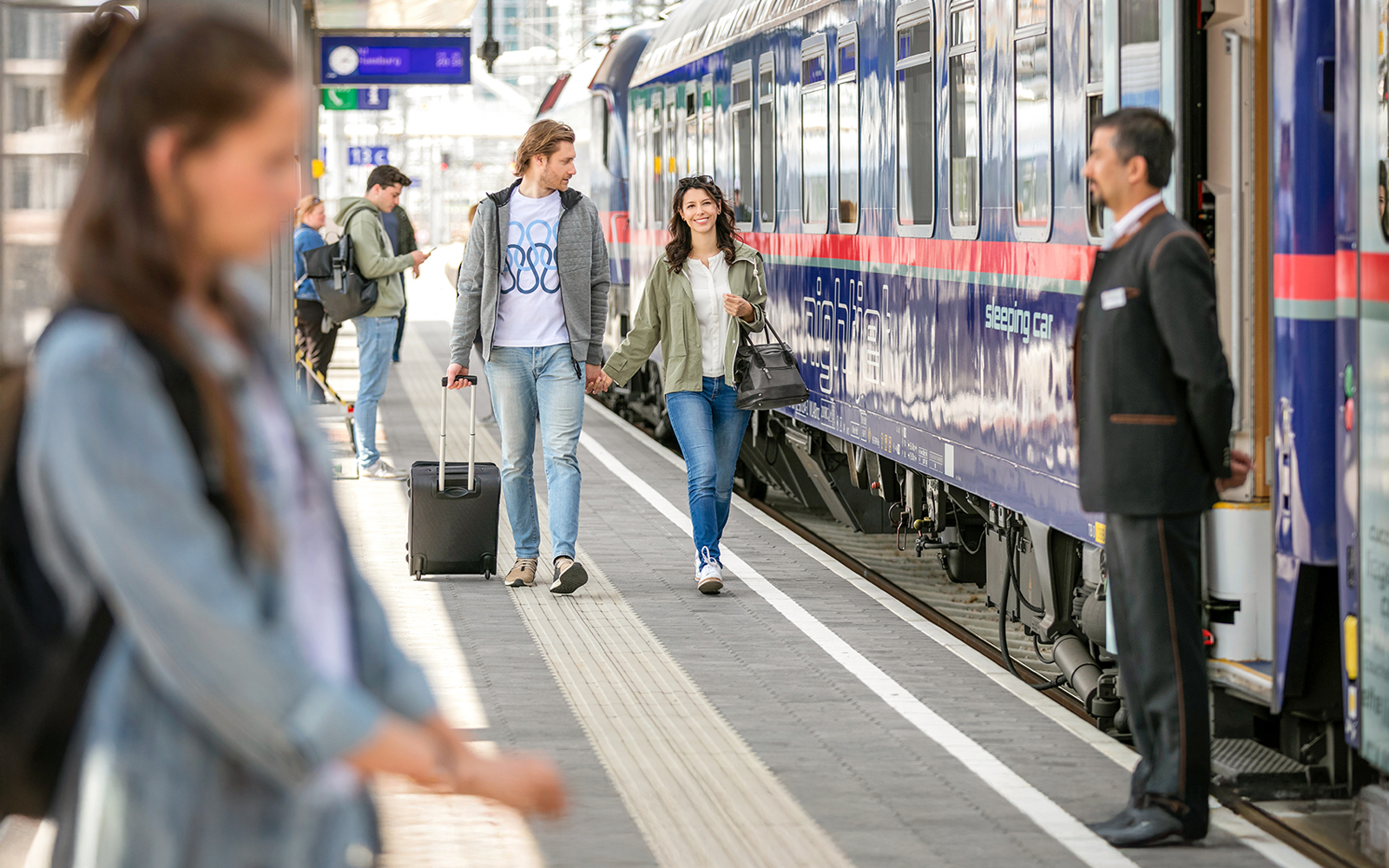 Couple boarding Eurail train at station platform.