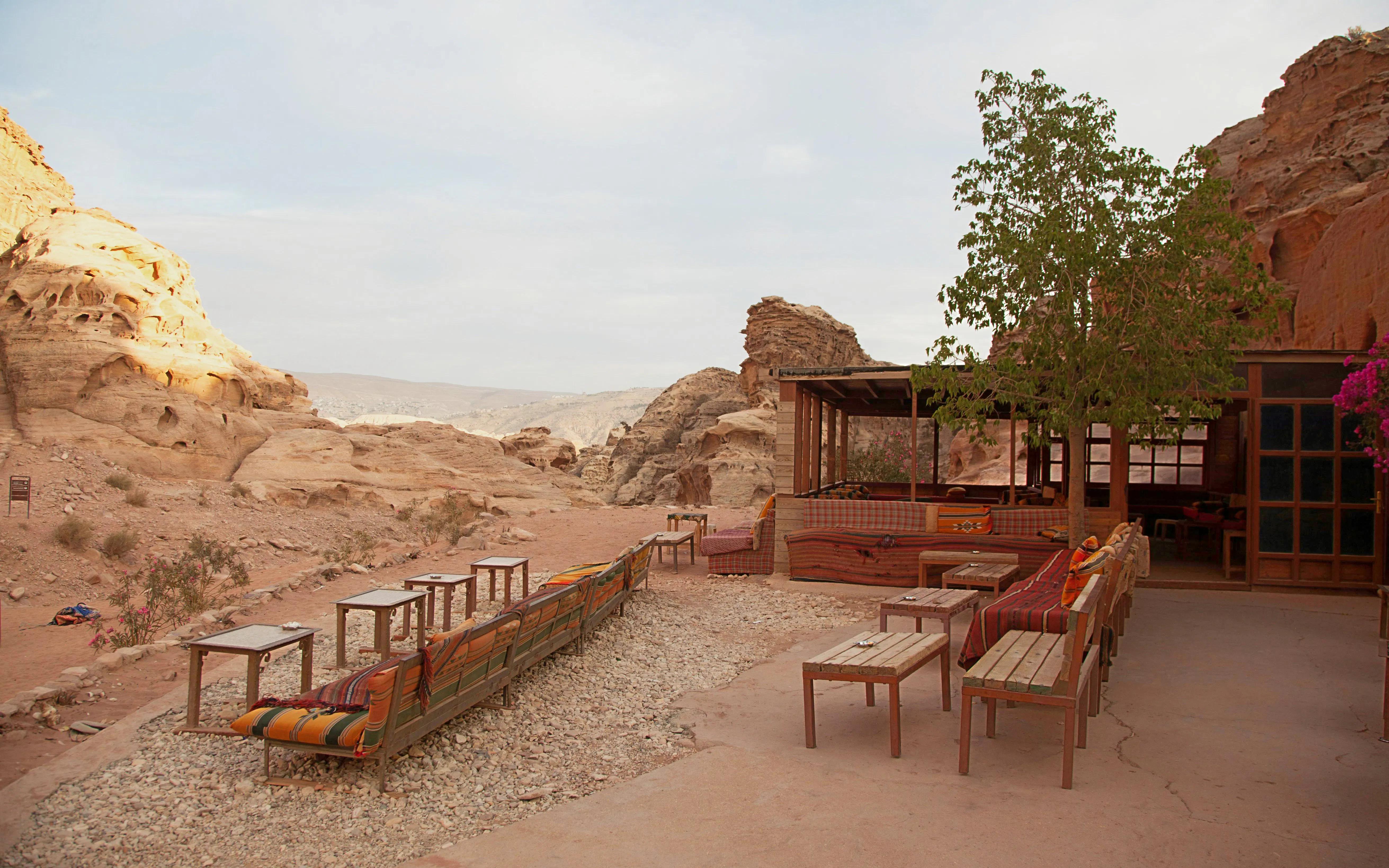 Souvenir stall and cafe with seating in Petra, Jordan's ancient city landscape.