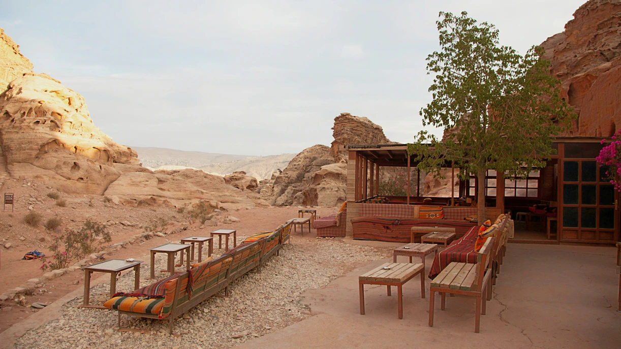 Souvenir stall and cafe with seating in Petra, Jordan's ancient city landscape.