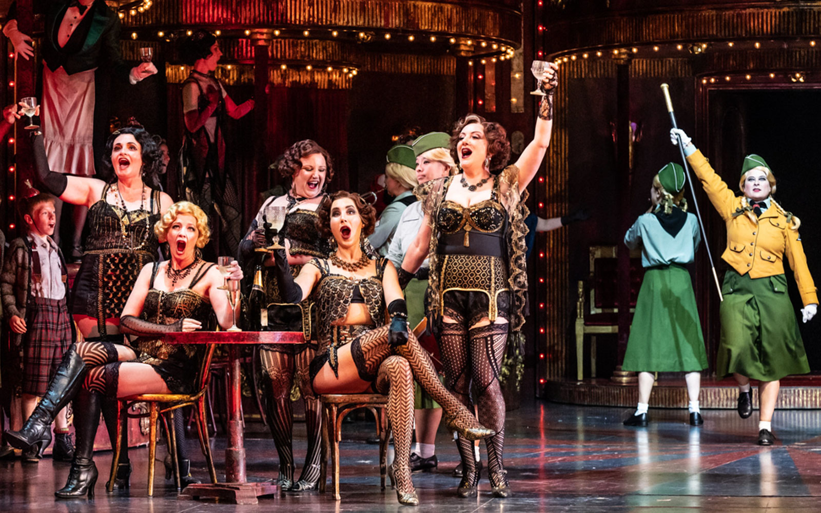 Opera performers in a lively scene from La Bohème, set in a vibrant Parisian café.