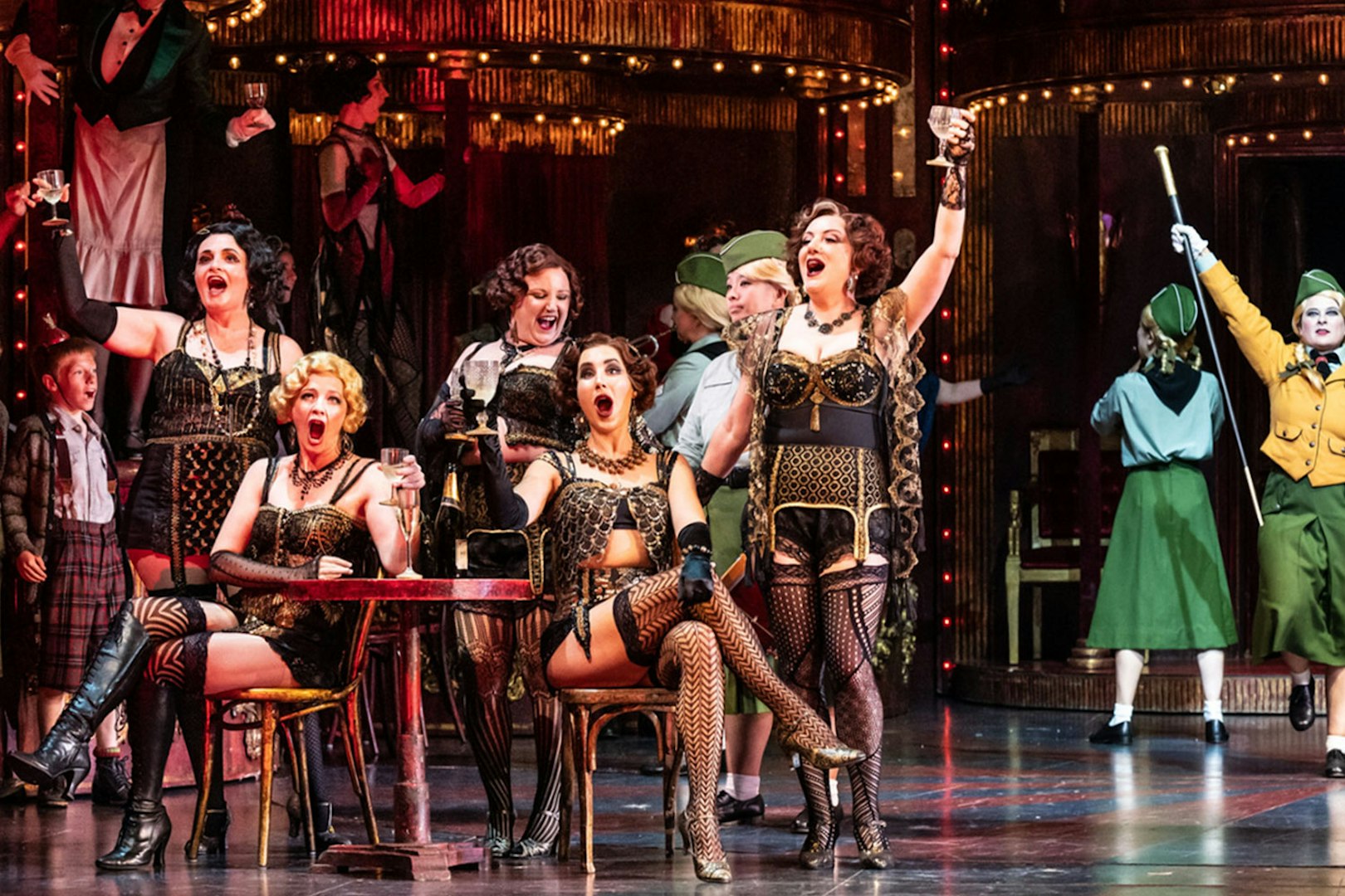 Opera performers in a lively scene from La Bohème, set in a vibrant Parisian café.