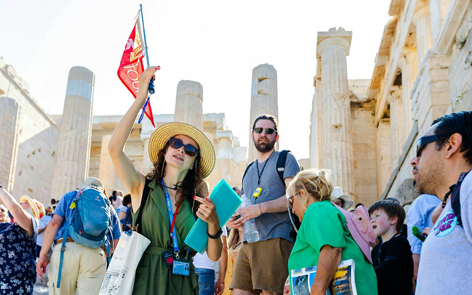 Tour guide leading a group at the Acropolis with Parthenon in the background, Athens.