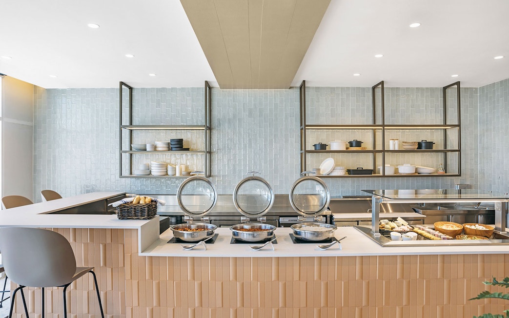 Buffet setup at Plaza Premium Lounge, International Arrival, featuring hot dishes and pastries.