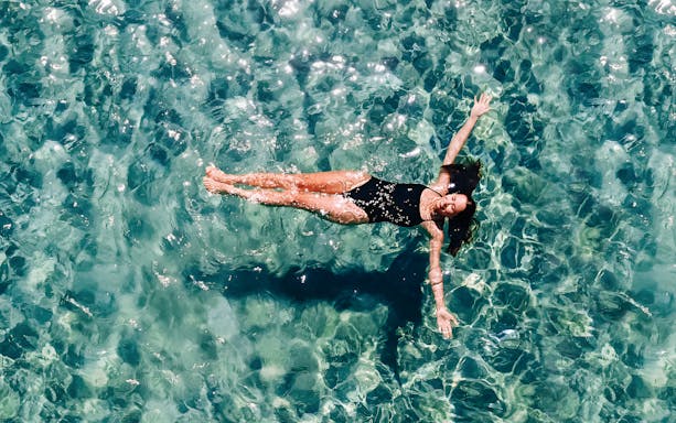 Person floating in clear water during Palma Bay boat tour.