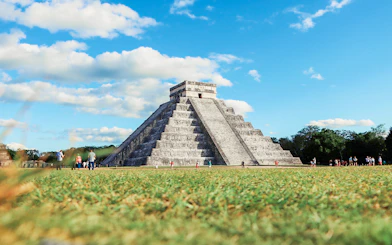 Tourists exploring El Castillo pyramid at Chichen Itza, Mexico.