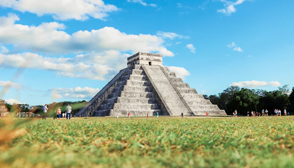 Tourists exploring El Castillo pyramid at Chichen Itza, Mexico.