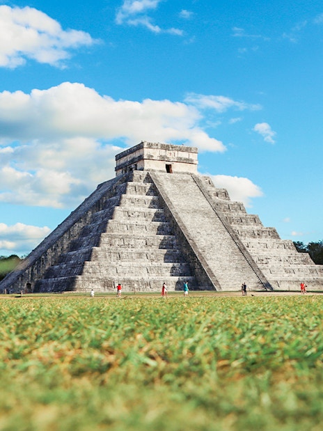 Tourists exploring El Castillo pyramid at Chichen Itza, Mexico.