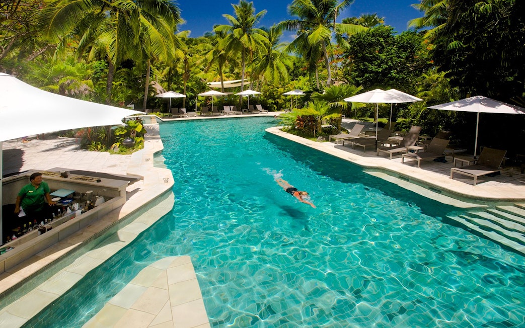 Swimming in a pool surrounded by palm trees on Castaway Island, Fiji.