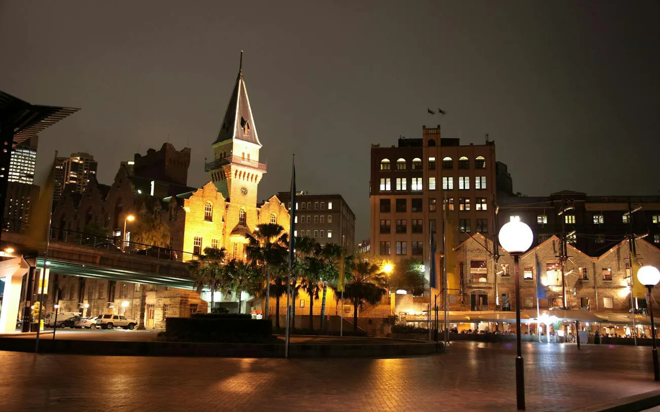 Historic buildings illuminated at night in Sydney, part of the QVB Ghost self-guided city exploration game.