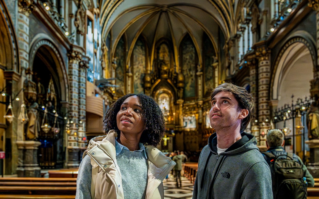 Tourists admiring the interior of Montserrat Monastery, Spain.