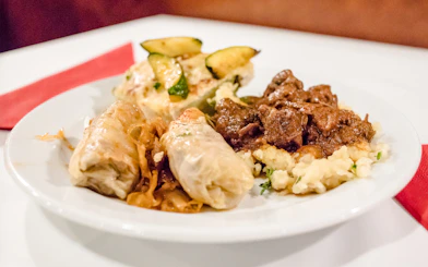 Traditional Hungarian dishes on a plate during a Danube dinner cruise buffet.