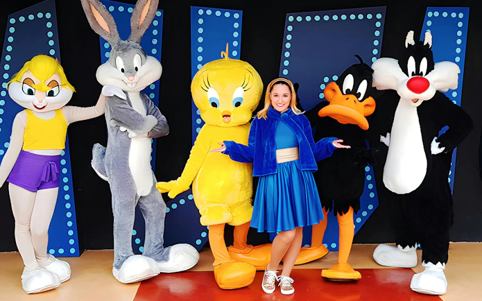 Characters posing with a visitor at Parque Warner night event.