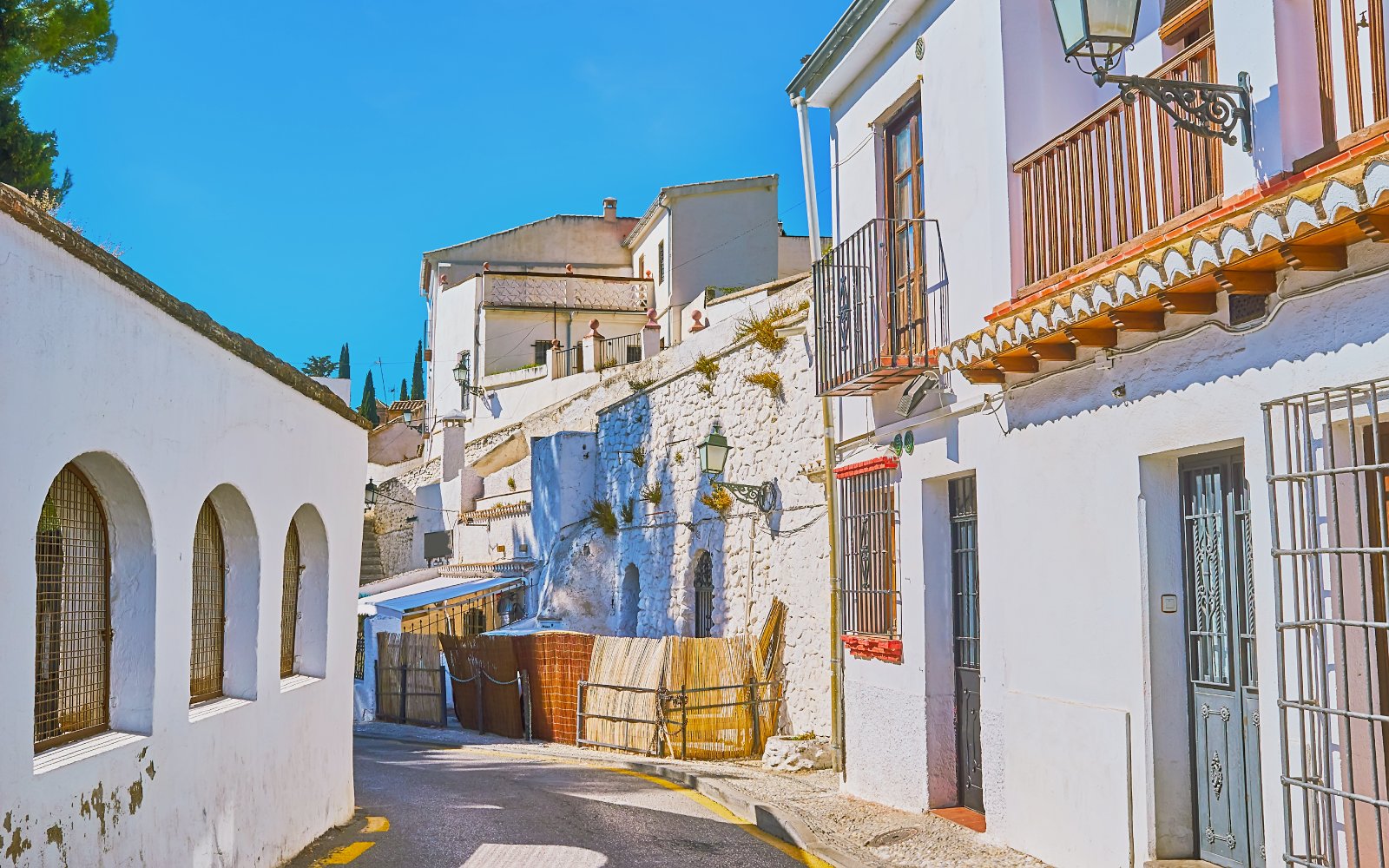 Narrow street with whitewashed buildings in Sacromonte, Granada, Spain.