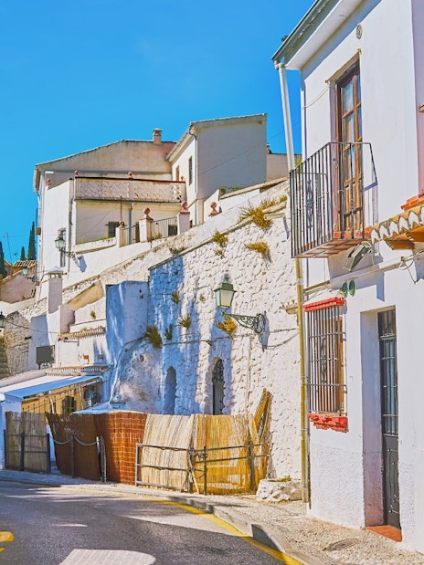 Narrow street with whitewashed buildings in Sacromonte, Granada, Spain.