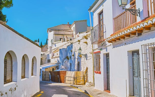 Narrow street with whitewashed buildings in Sacromonte, Granada, Spain.