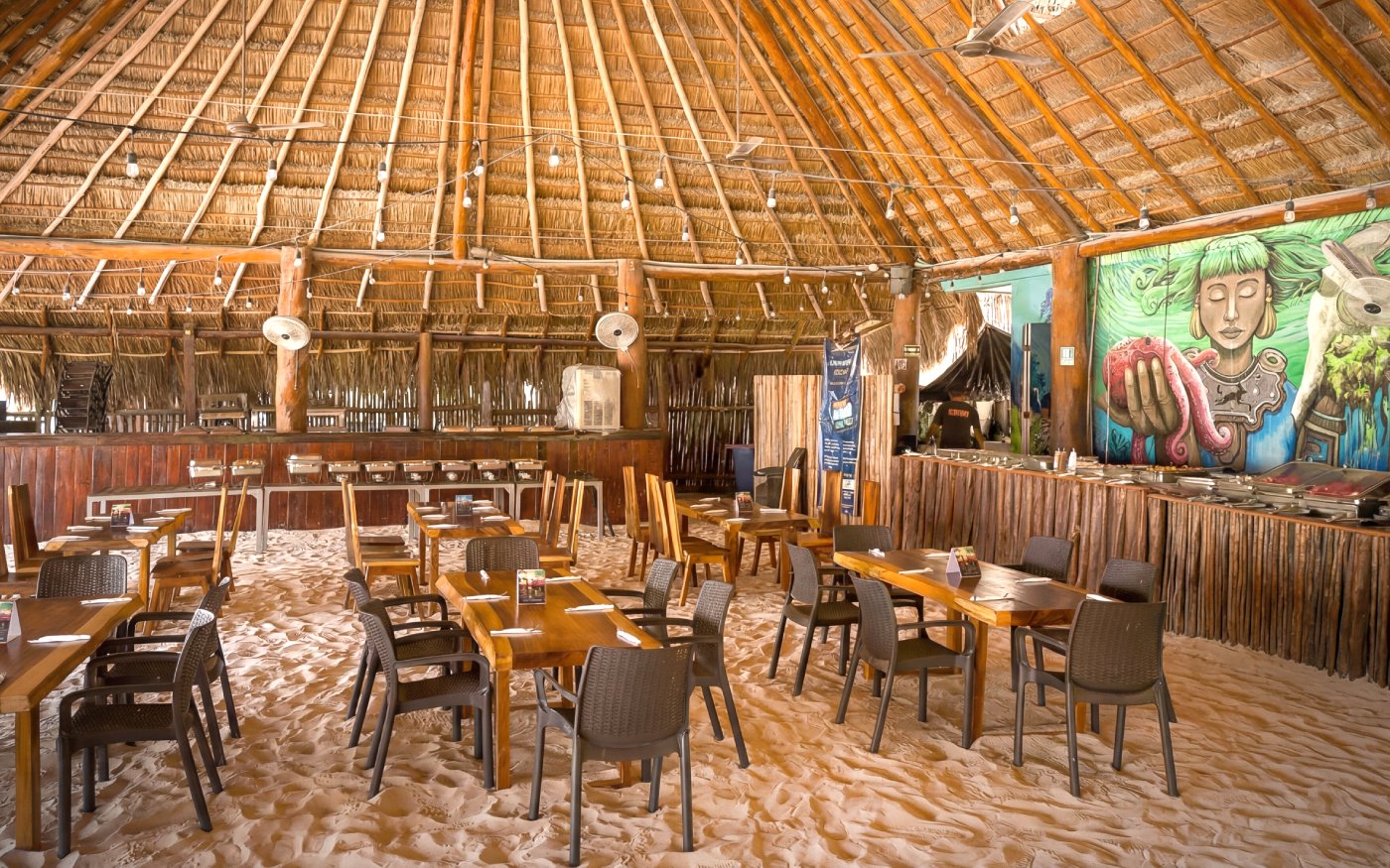 Beach club dining area with sand floor and mural, Isla Mujeres.