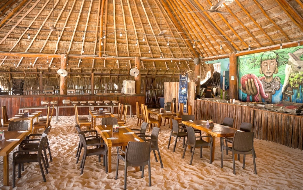 Beach club dining area with sand floor and mural, Isla Mujeres.