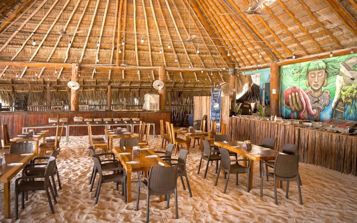 Beach club dining area with sand floor and mural, Isla Mujeres.