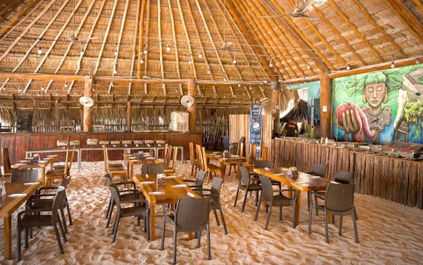 Beach club dining area with sand floor and mural, Isla Mujeres.