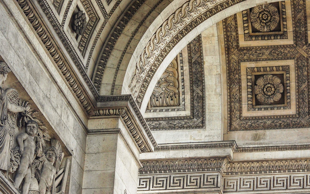 Close-up of intricate carvings and sculptures on the Arc de Triomphe in Paris.