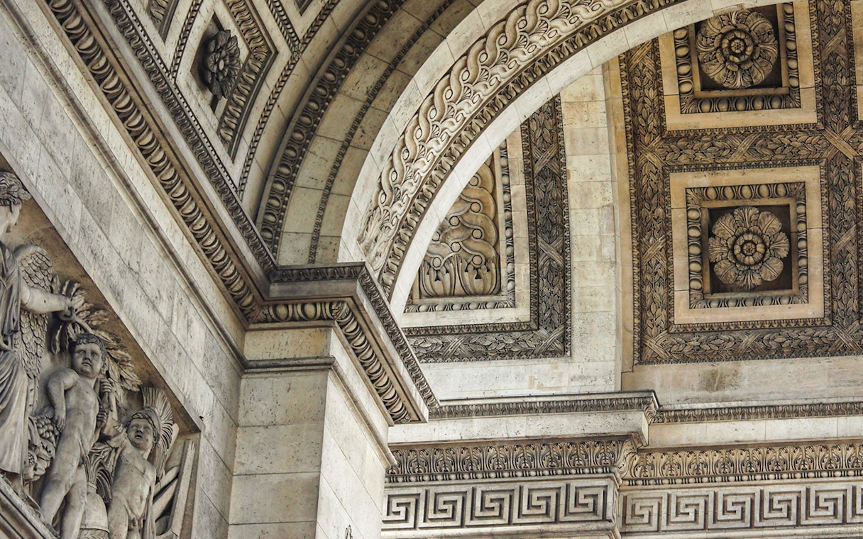 Close-up of intricate carvings and sculptures on the Arc de Triomphe in Paris.