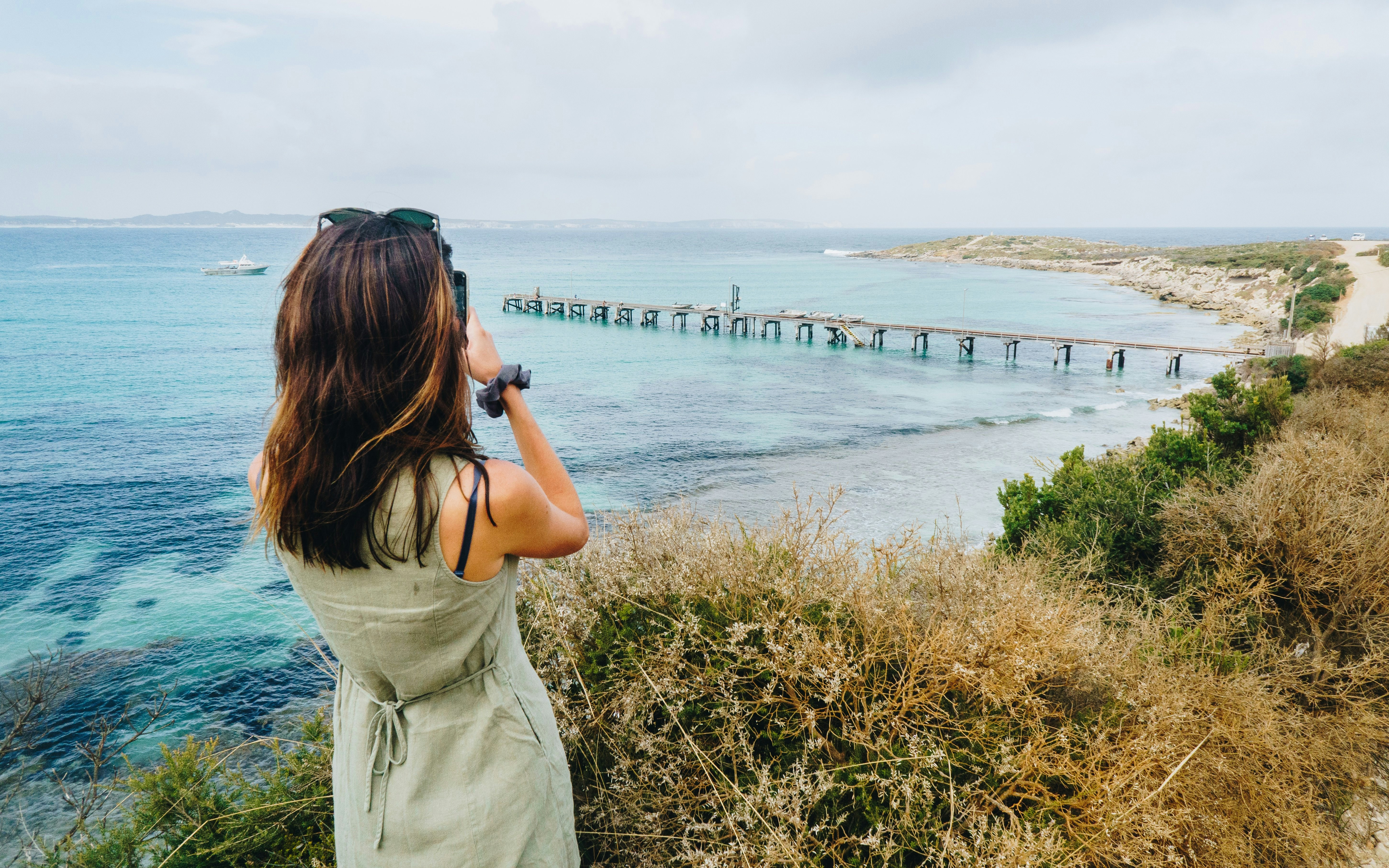 Woman photographing Vivonne Bay Jetty on Kangaroo Island, South Australia.