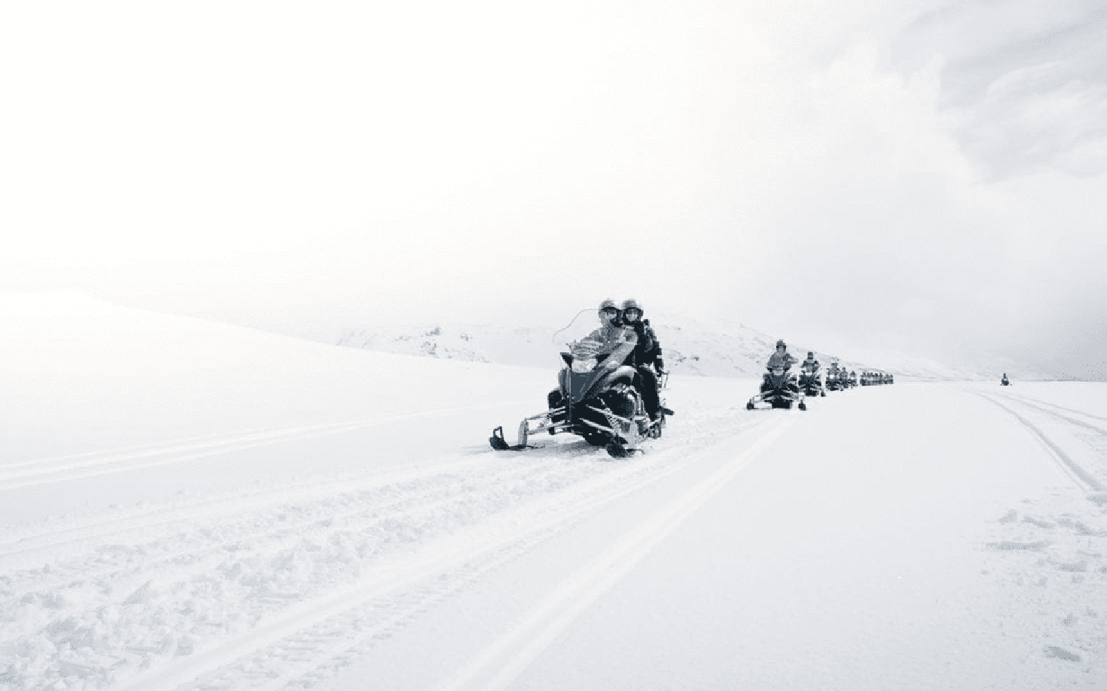 Snowmobilers on glacier during Secret Lagoon hot spring tour in Iceland.