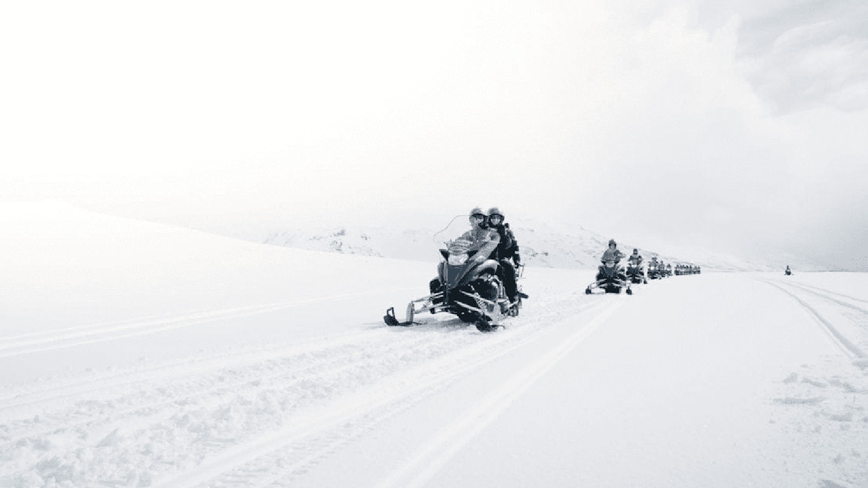 Snowmobilers on glacier during Secret Lagoon hot spring tour in Iceland.