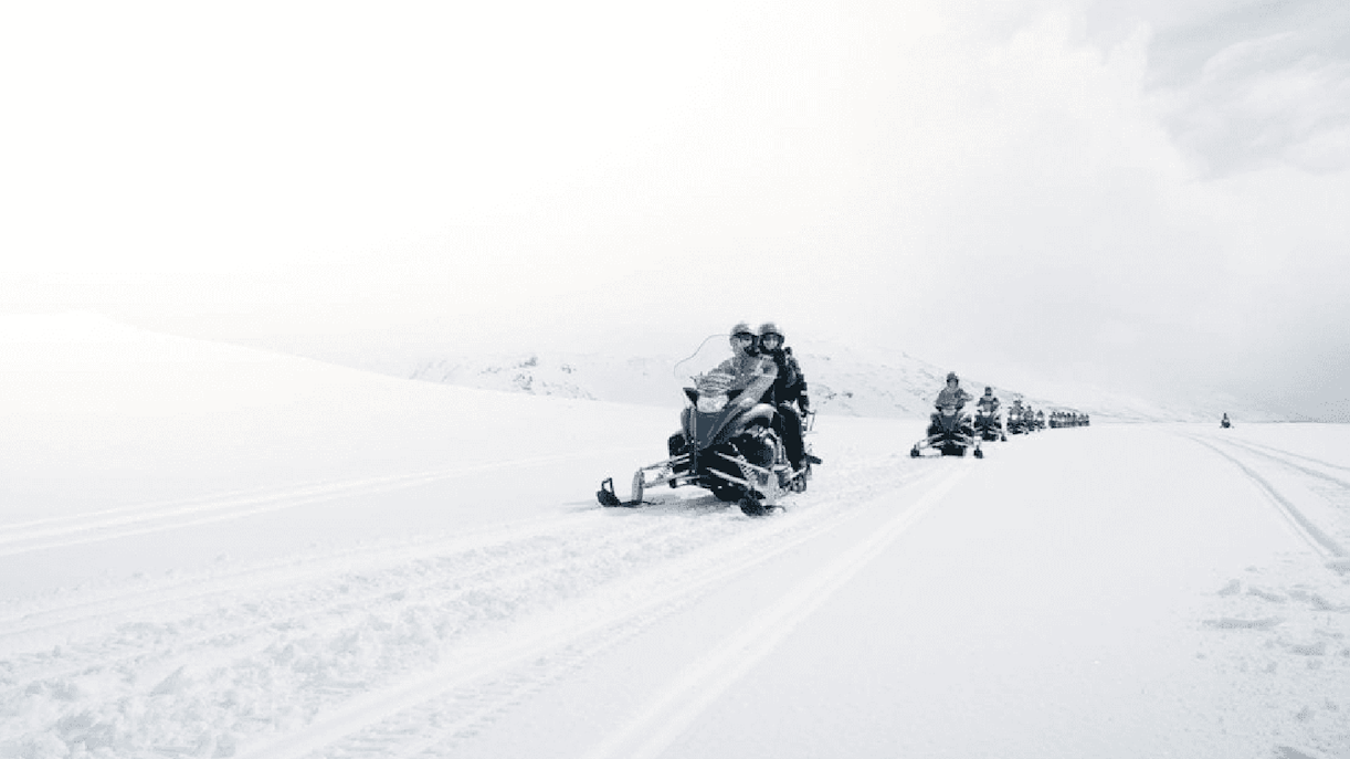 Snowmobilers on glacier during Secret Lagoon hot spring tour in Iceland.
