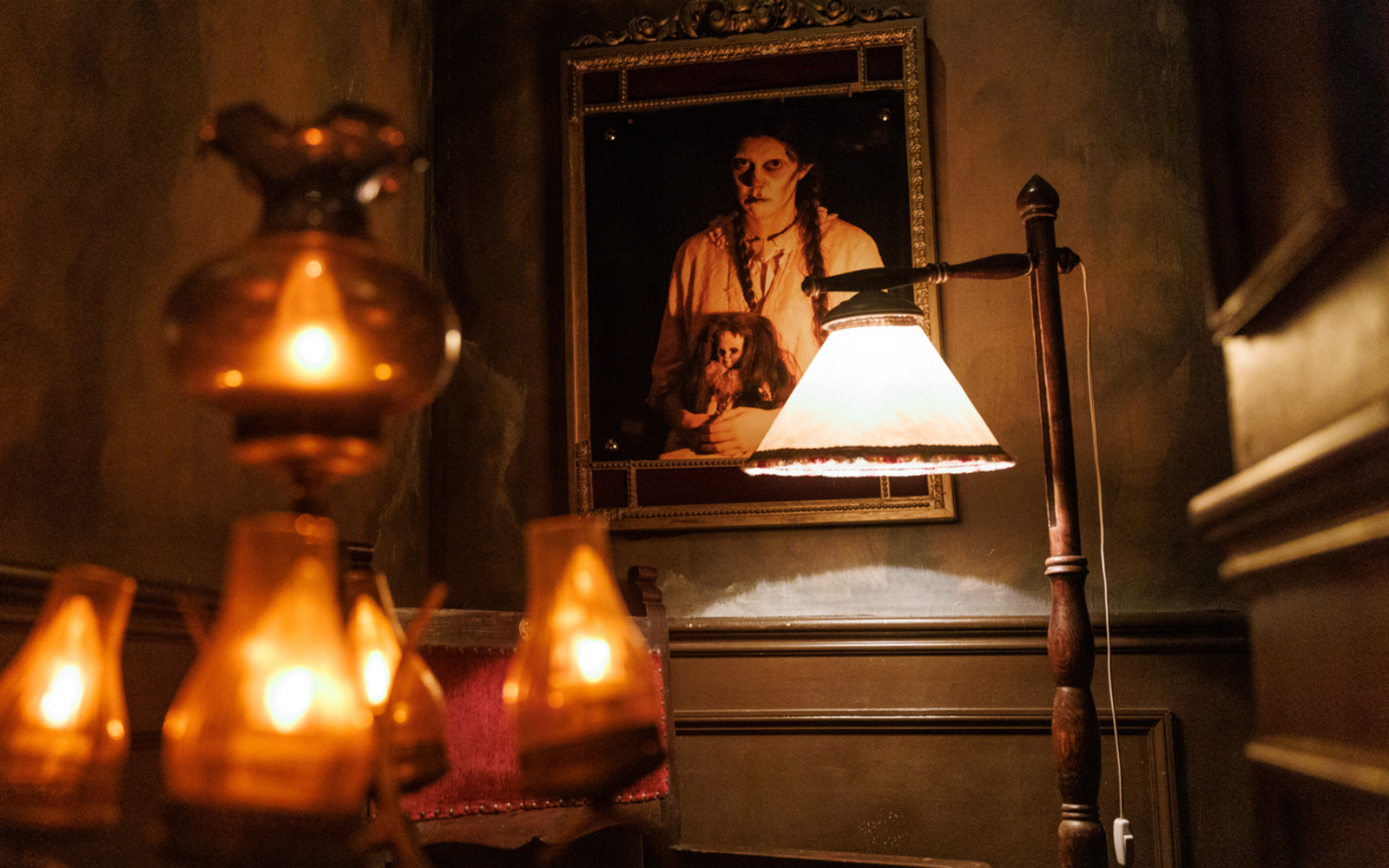 Dimly lit room with eerie portrait at Hotel 666, Tibidabo Amusement Park.