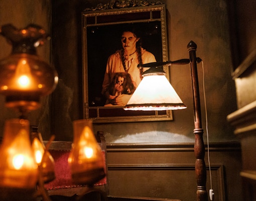 Dimly lit room with eerie portrait at Hotel 666, Tibidabo Amusement Park.