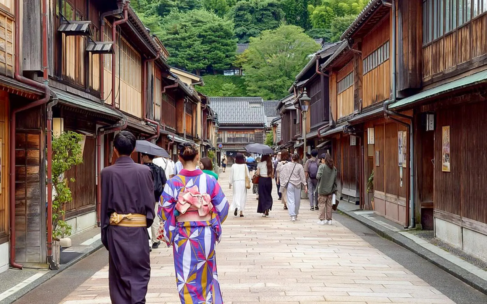 Visitors walking through Higashi Chaya District in Kanazawa, wearing traditional kimonos.
