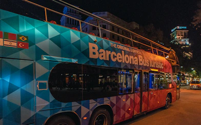 Barcelona Bus Turistic at night on a city street.