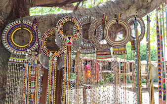 Traditional Maasai beadwork displayed on a tree during Nairobi city tour.