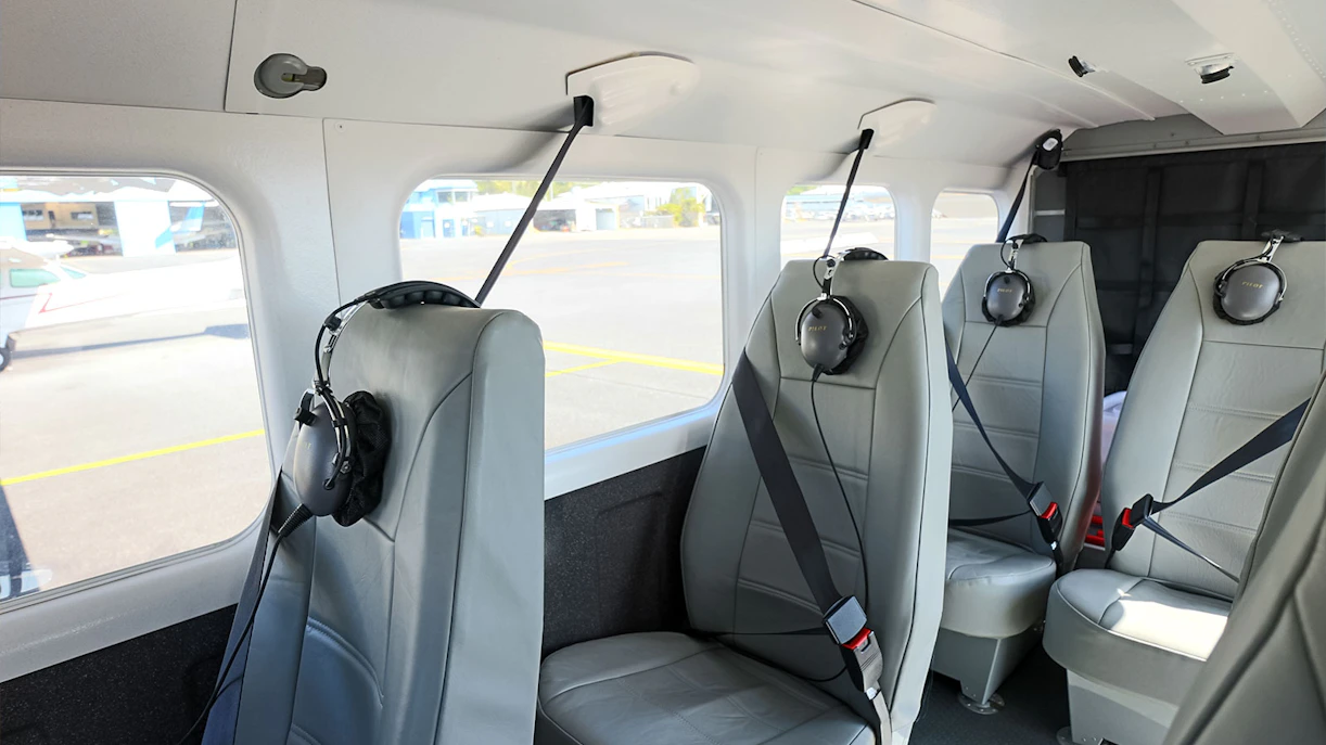 Interior seating of a small aircraft at Cairns Airport with headsets on seats.