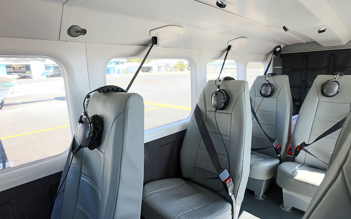 Interior seating of a small aircraft at Cairns Airport with headsets on seats.