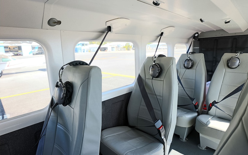 Interior seating of a small aircraft at Cairns Airport with headsets on seats.