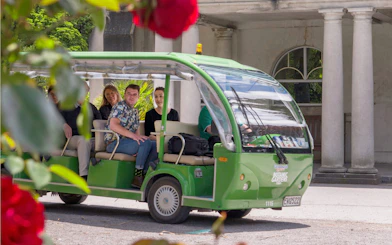 Tourists on a green shuttle at Christchurch Botanic Gardens.