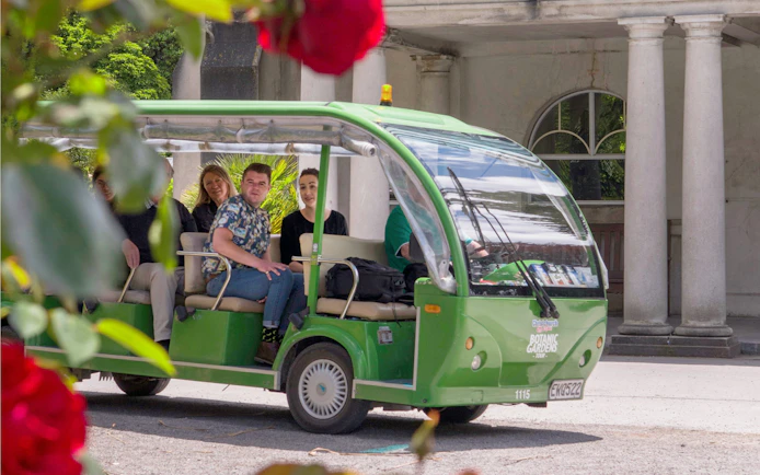 Tourists on a green shuttle at Christchurch Botanic Gardens.