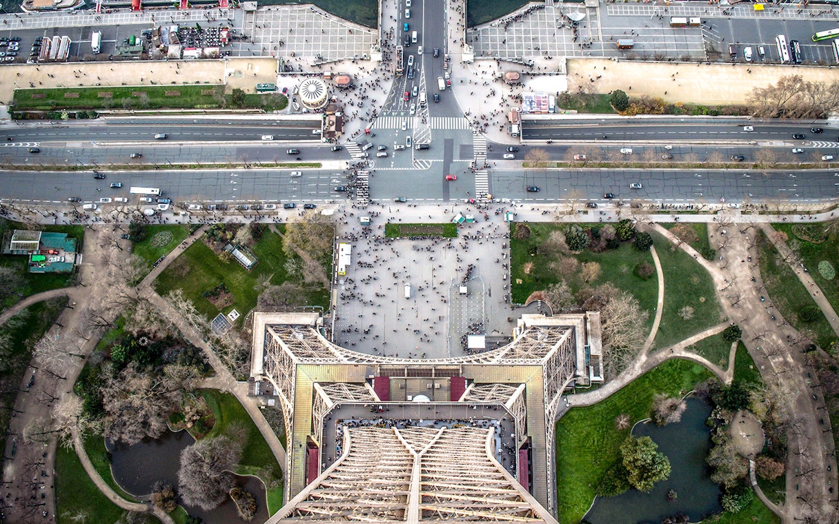 Aerial view from the Eiffel Tower, Paris, showing surrounding streets and gardens.