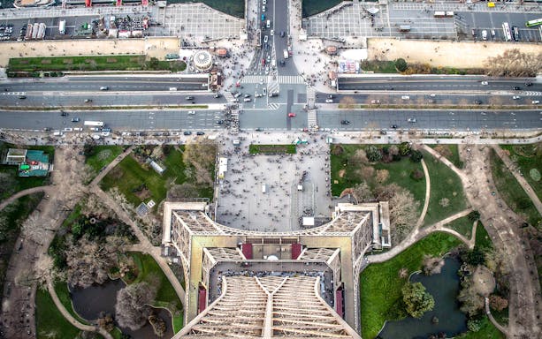 Aerial view from the Eiffel Tower, Paris, showing surrounding streets and gardens.