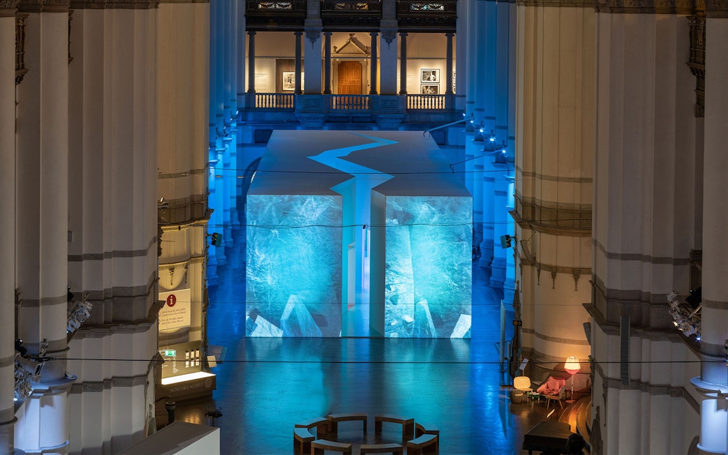 Stockholm museum interior with illuminated blue art installation.