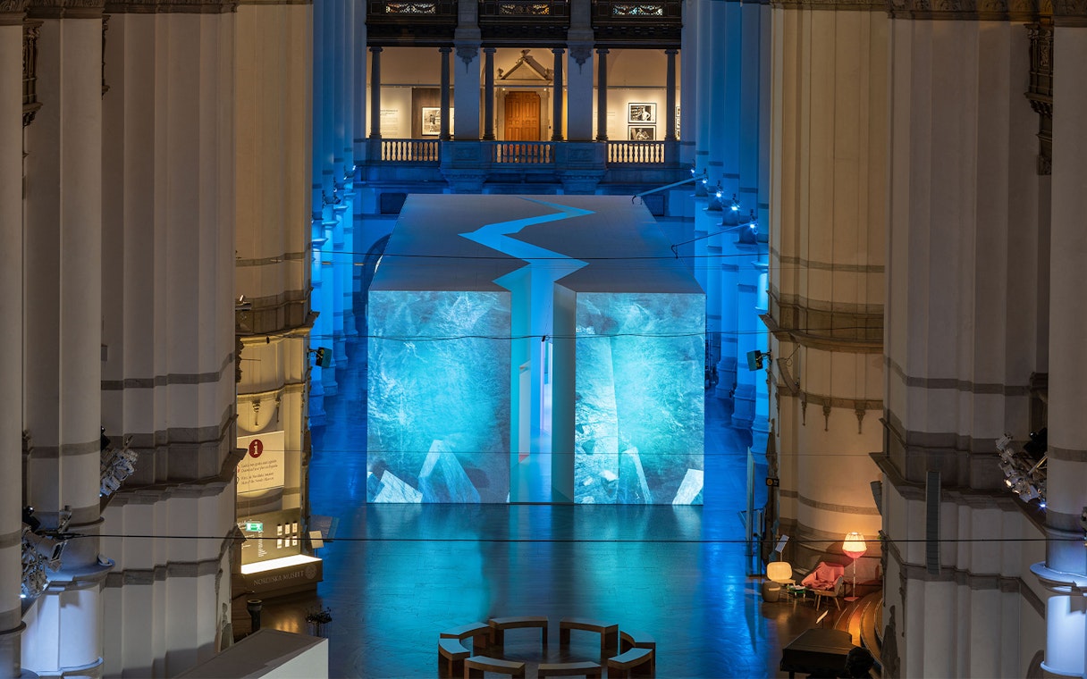 Stockholm museum interior with illuminated blue art installation.