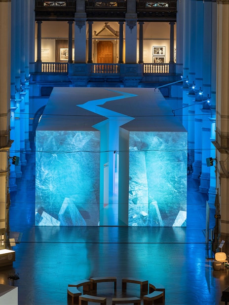 Stockholm museum interior with illuminated blue art installation.