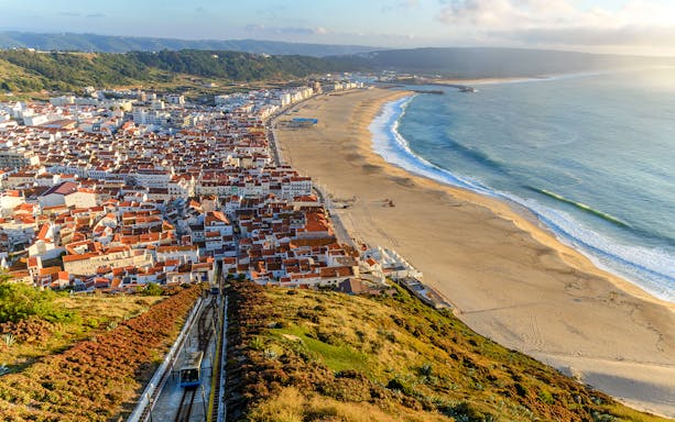 Aerial view of Nazare city and Praia da Nazare Beach, Portugal, with funicular railway.