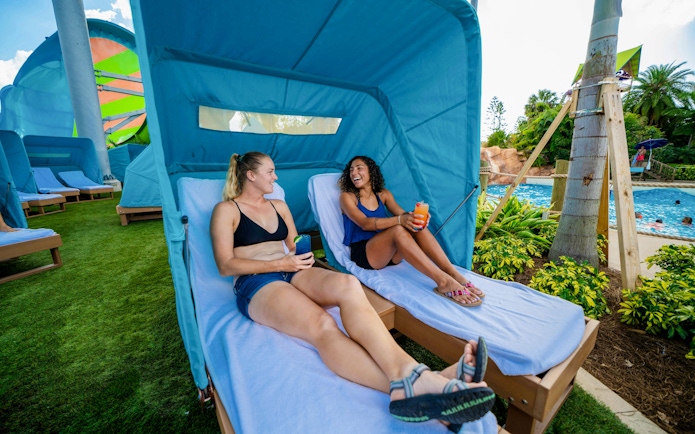 Guests relaxing in cabanas by the pool at Aquatica Orlando.