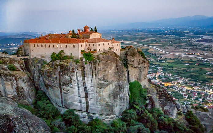 Monastery of Holy Trinity perched on a cliff in Meteora, Greece, overlooking the valley.