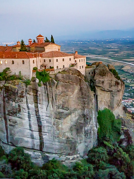 Monastery of Holy Trinity perched on a cliff in Meteora, Greece, overlooking the valley.