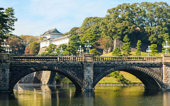 Bridge overlooking Tokyo Imperial Palace with surrounding trees and water.